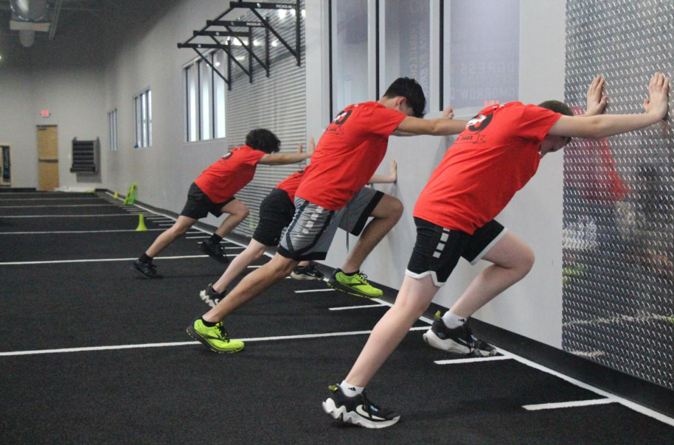 Teen athlete in a Parisi shirt sprinting during a speed drill